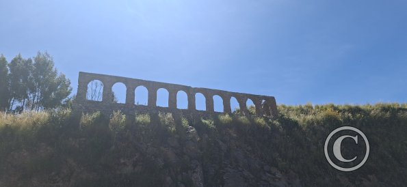 arches in a wall alongside the highway